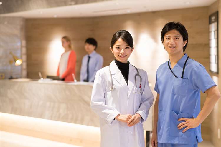 Image of medical personnel standing in front of the reception counter
