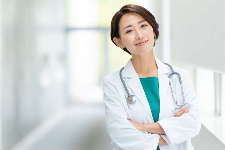 Image d'une femme médecin avec un sourire et les bras croisés